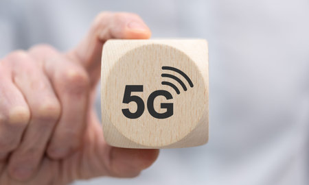 Hand holding a wooden cube with symbol of 5g conceptの写真素材