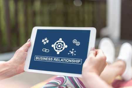 Female hands holding a tablet with business relationship conceptの写真素材