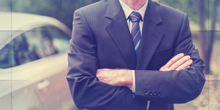 Businessman standing with arm crossed in front of his car, geometric patternの写真素材