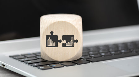Wooden block with symbol of m&a concept on laptop keyboard