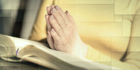 Close up of woman praying with her hands over the bible, geometric patternの写真素材