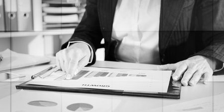 Businesswoman pointing her finger on a graph showing growth, geometric patternの写真素材