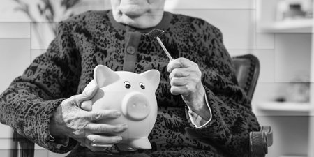 Senior woman holding a piggy bank, geometric patternの写真素材