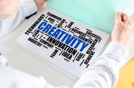 Man holding a file with creativity word cloud conceptの写真素材