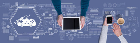 Top view of hands using digital tablet and mobile phone with symbol of video game addiction concept