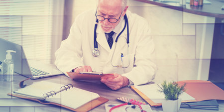 Senior doctor reading a clinical record in medical office, geometric pattern