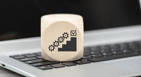Wooden block with symbol of action plan concept on laptop keyboard