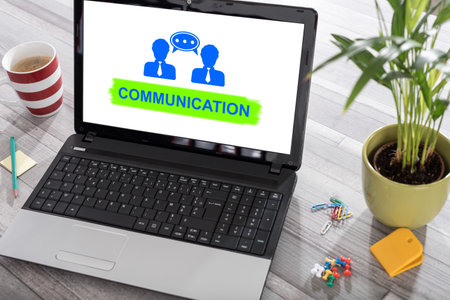 Laptop on a desk with communication concept on the screenの写真素材