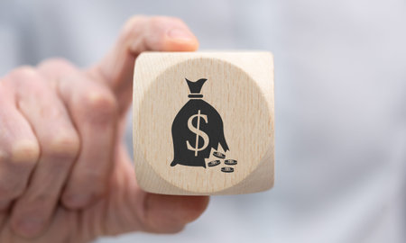 Hand holding a wooden cube with symbol of financial crisis conceptの写真素材