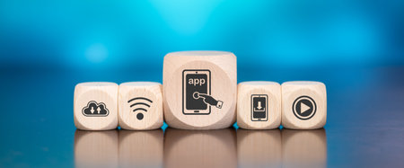 Wooden blocks with symbol of app concept on blue backgroundの写真素材
