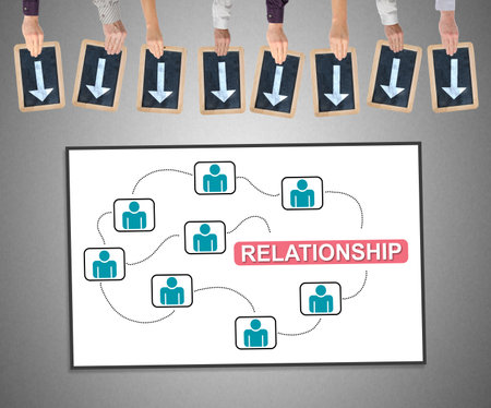 Hands holding writing slates with arrows pointing on relationship conceptの写真素材