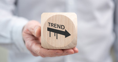 Hand holding a wooden cube with symbol of trends concept