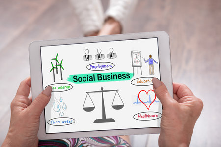 Social business concept shown on a tablet held by a womanの写真素材