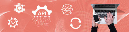 Top view of hands using laptop and mobile phone with symbol of api concept