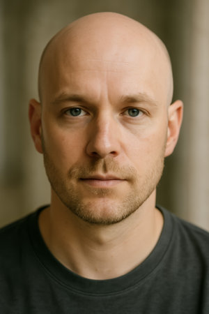 A close-up portrait of a bald man featuring a serious expression and stubbleの素材