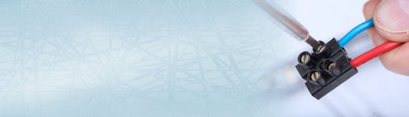 Clamping a wire in a connector, closeup; panoramic banner
