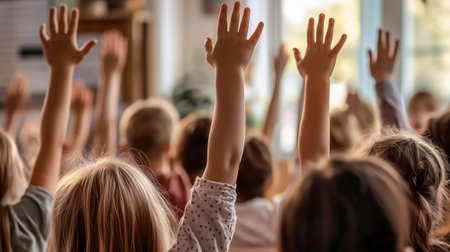 A group of children enthusiastically raising their hands in a bright classroom environmentの素材