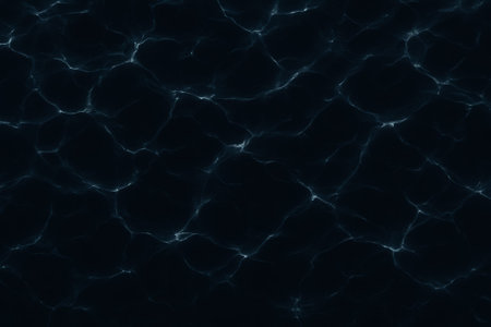 A smooth, dark water surface featuring ripples and light reflections in shades of blueの素材