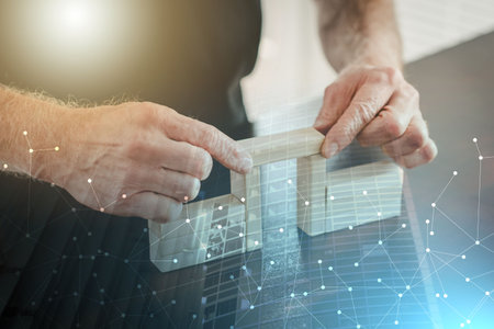 Hands building a wooden block bridge; concept of business association; multiple exposureの写真素材