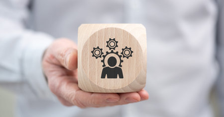 Hand holding a wooden cube with symbol of competence conceptの写真素材