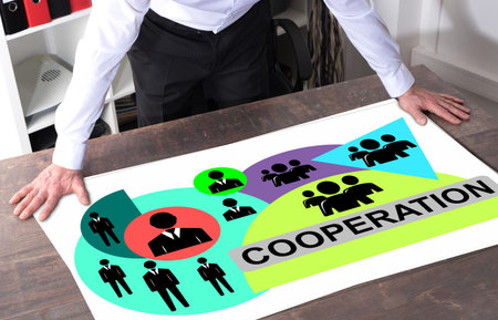 Man watching a cooperation concept placed on a deskの写真素材