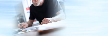 Senior man working in office, hard light effect; panoramic bannerの写真素材