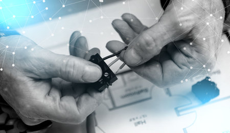Electrician hands connecting wires in terminal block; light effect