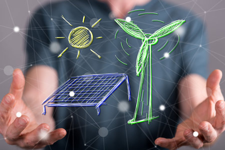 Green energy concept between hands of a man in backgroundの写真素材