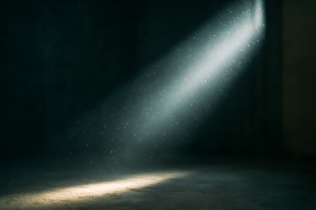 A stunning beam of light illuminating a dusty area within a dark roomの素材