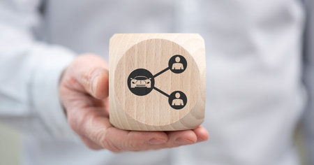 Hand holding a wooden cube with symbol of car sharing conceptの写真素材