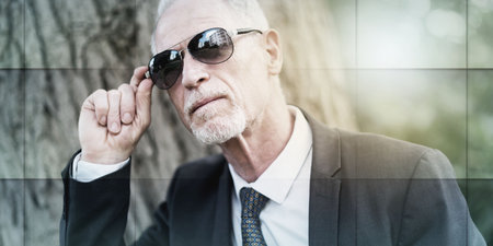 Portrait of mature man wearing sunglasses outdoors, light effect, geometric patternの写真素材