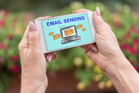 Female hands holding a smartphone with email sending concept