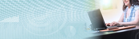 Young attractive businesswoman working on laptop at office, light effect; panoramic bannerの写真素材