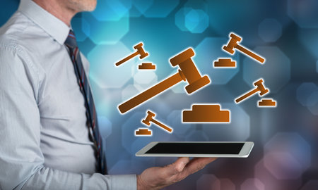 Judgment concept above a tablet held by a manの写真素材