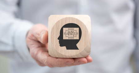 Hand holding a wooden cube with symbol of machine learning conceptの写真素材