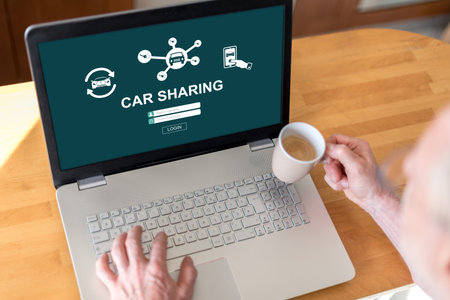 Man using a laptop with car sharing concept on the screen