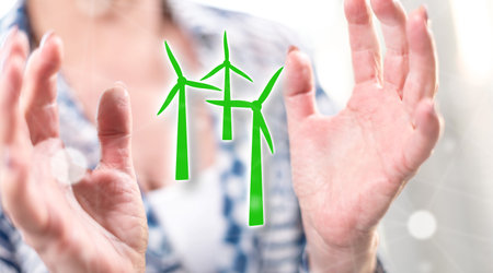Clean energy concept between hands of a woman in background