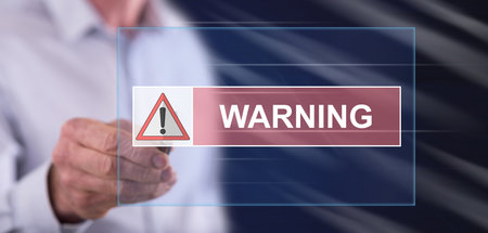 Man touching a warning concept on a touch screen with a penの写真素材