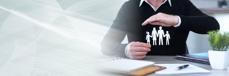 Insure protecting a family with his hand; panoramic bannerの写真素材