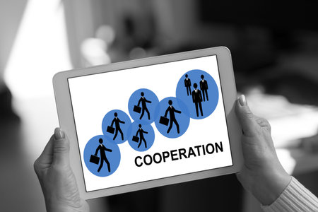 Cooperation concept shown on a tablet held by a womanの写真素材