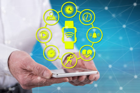 Wearable technology concept above a smartphone held by hands