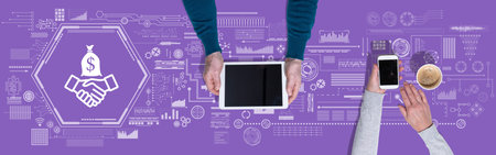Top view of hands using digital tablet and mobile phone with symbol of investment concept