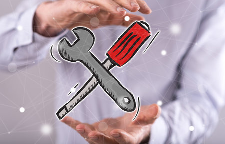 Maintenance service concept between hands of a man in backgroundの写真素材