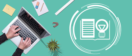 Top view of hands using laptop with symbol of knowledge concept