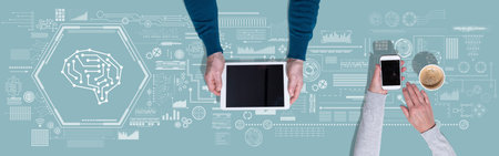 Top view of hands using digital tablet and mobile phone with symbol of artificial intelligence...
