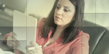 Young attractive businesswoman using a tablet at office, light effect, geometric pattern