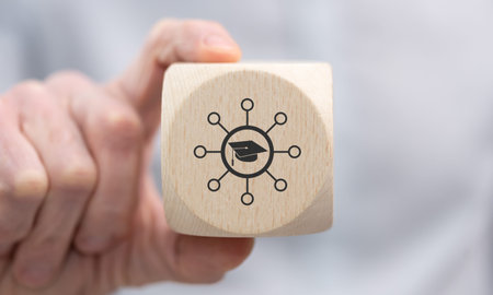 Hand holding a wooden cube with symbol of knowledge sharing concept