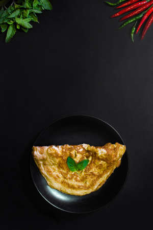 Picture of an appetizing yellow omelette on a black background There is space to put text. Street food, Image from the top viewの写真素材