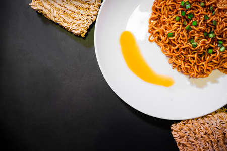 Korean spicy hot instant noodles on a black background, picture from the top view of instant noodlesの写真素材