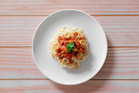Pasta, Spaghetti bolognese served on a white plate and tomato sauce on wood backgroundの写真素材